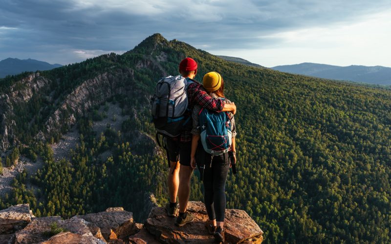 A happy couple in the mountains admires the beautiful views
